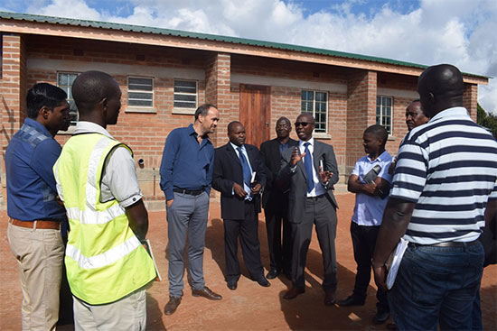 Charles Lumanga, Head of Operations at NAO Support Unit commenting on classic progress of construction works at Chibabvi CDSS whilst behind one of the newly built classrooms Charles Lumanga, Head of Operations at NAO Support Unit commenting on classic progress of construction works at Chibabvi CDSS whilst behind one of the newly built classrooms